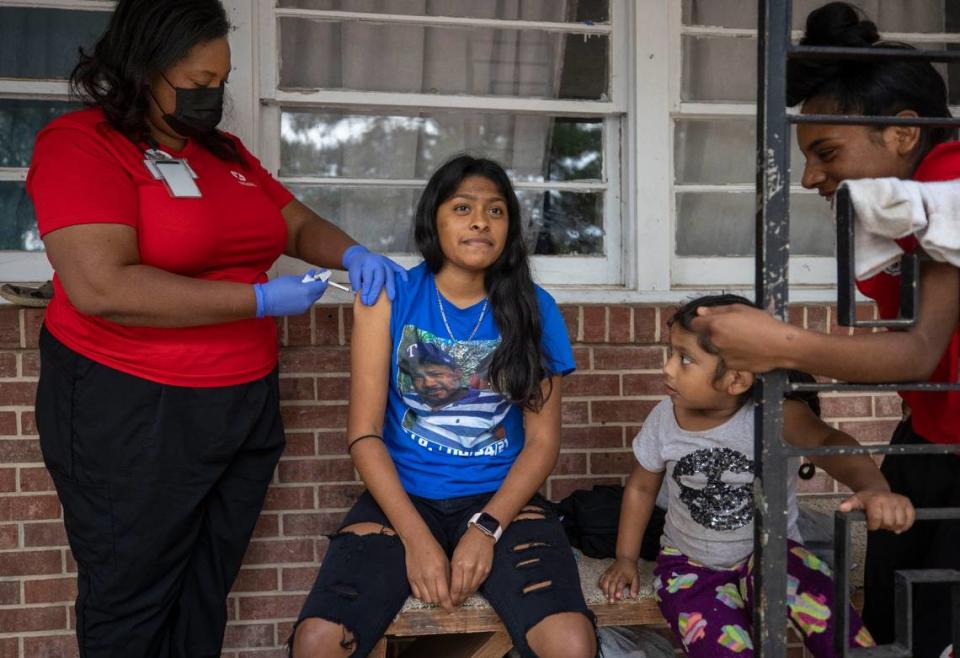 Fifteen-year-old Emily Gutierrez receives her second dose of COVID-19 vaccine from Dr. Nerissa Price, as her sisters Josleni Gutierrez and Eily Gutierrez watch on Friday, October 8, 2021 in Raleigh, N.C.