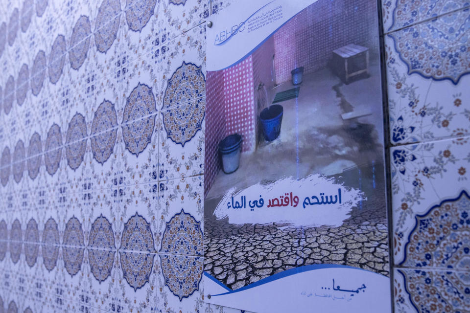 A notice poster encourages people to preserve water inside a Moroccan traditional bath, known as hammam, while it is empty of customers, in Rabat, Morocco, Monday, March 4, 2024. Climate change and a yearslong drought have forced Morocco's famous public baths to close a few days a week in an effort to save water. The poster in Arabic reads, "Shower while preserving water." (AP Photo/Mosa'ab Elshamy)
