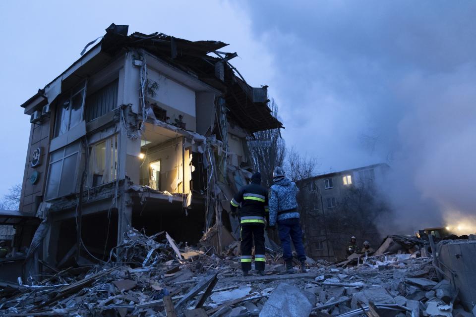 Smoke rises as Donetsk's emergency employees work at a site of a shopping center destroyed following what Russian officials in Donetsk said it was a shelling by Ukrainian forces, in Donetsk, in Russian-controlled Donetsk region, eastern Ukraine, Monday, Jan. 16, 2023. (AP Photo/Alexei Alexandrov)