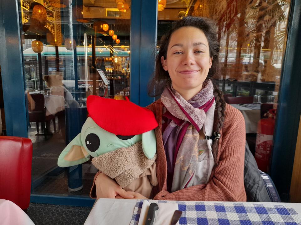 the writer with a stuffed baby yoda in a paris cafe