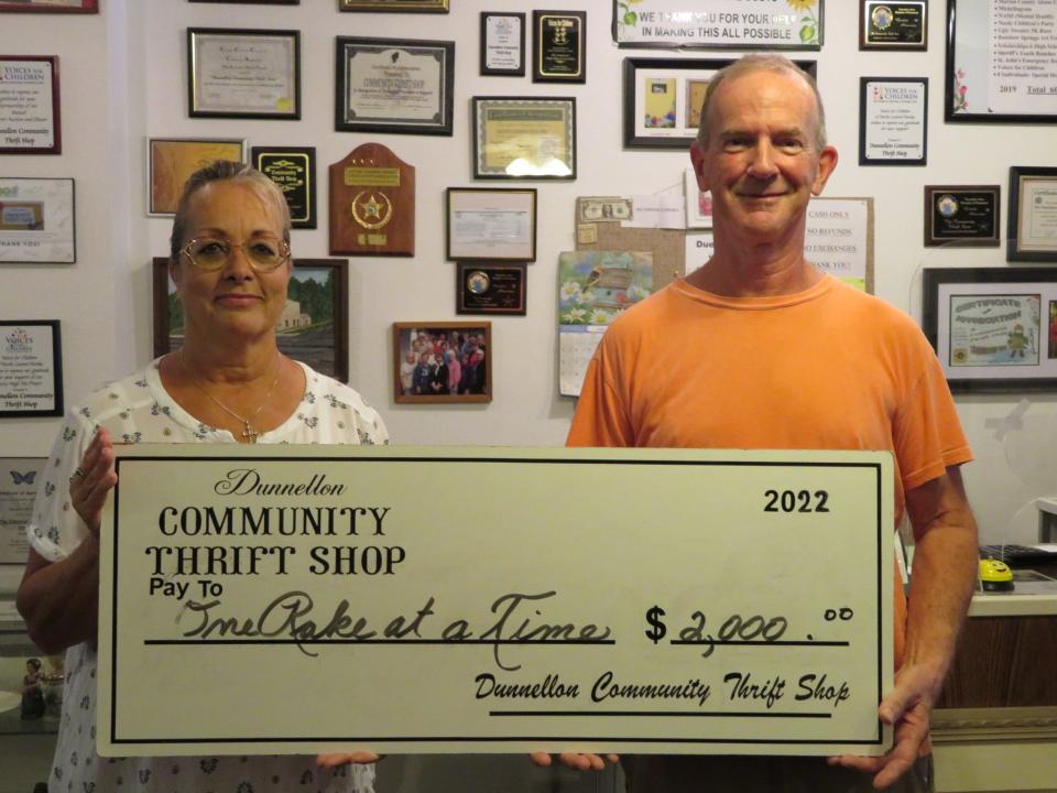 Dunnellon Community Thrift Shop volunteer Kim Hatfield presents a $2,000 check to Art Jones, president of One Rake at a Time.