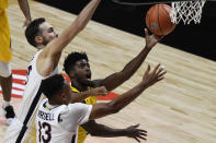 Towson's Cam Allen, center, shoots between Virginia's Jay Huff, left, and Virginia's Casey Morsell, right, in the first half of an NCAA college basketball game, Wednesday, Nov. 25, 2020, in Uncasville, Conn. (AP Photo/Jessica Hill)