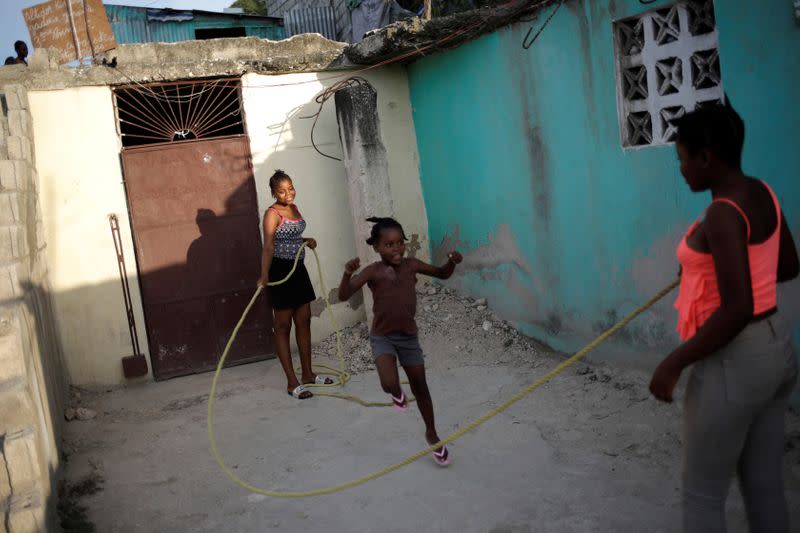 Nickerla Ambroise Etienne and her sister Jessica Sachara Etienne play outside their house in Port-au-Prince