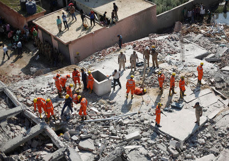 Rescue workers look for survivors amidst the rubble at the site of a collapsed residential building at Shah Beri village in Greater Noida, July 18, 2018. REUTERS/Adnan Abidi