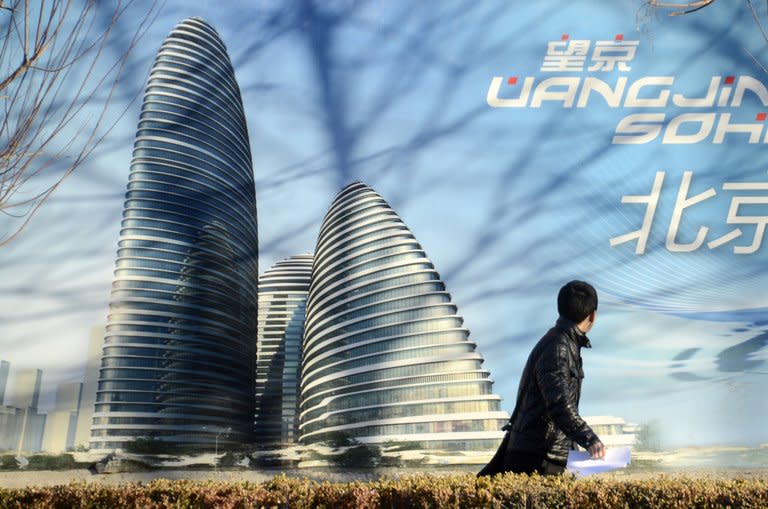 A Chinese man walks past a billboard illustrating the Wang Jing SOHO complex by renowned architect Zaha Hadid in Beijing on January 3, 2013. Already famed for fake designer bags and pirated DVDs, imitation in China may have reached new heights with a set of towers that strongly resemble ones designed by Hadid