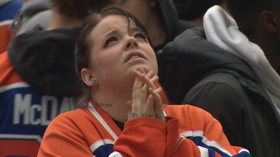 A woman watches the Oilers-Panthers game on June 8, 2024, while at the street party outside of Rogers Place in downtown Edmonton.