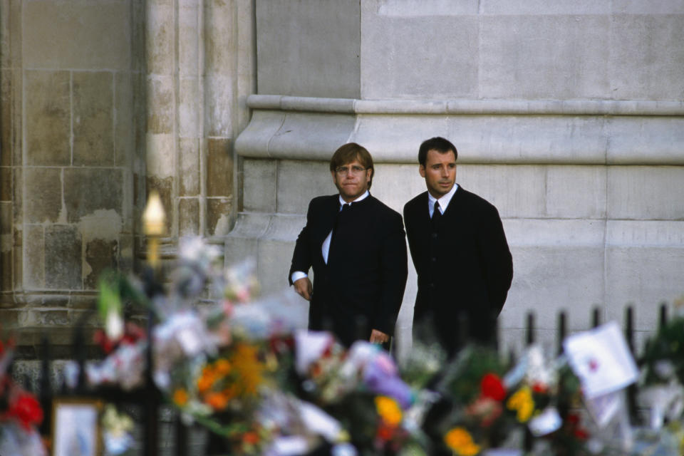 Singer Elton John arrives with David Furnish at the funeral of Diana, Princess of Wales, only seven days after she was killed in an automobile accident in Paris. At least a million people lined the streets of central London to watch the procession with Diana's coffin from Kensington Palace to Westminster Abbey. She was finally buried at Althorp House, the Spencer family home in Northamptonshire.   (Photo by Peter Turnley/Corbis/VCG via Getty Images)