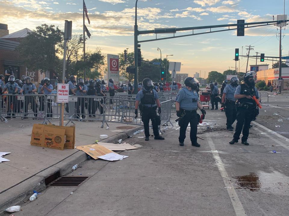 Minneapolis police monitor a crowd of people protesting the death of George Floyd on Wednesday night outside the Third Precinct.