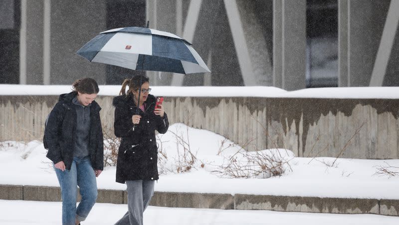 Assistant professor Anna Hodgson and University of Utah student Aubree Berrett walk through the snow at the University of Utah campus in Salt Lake City on April 4, 2023.