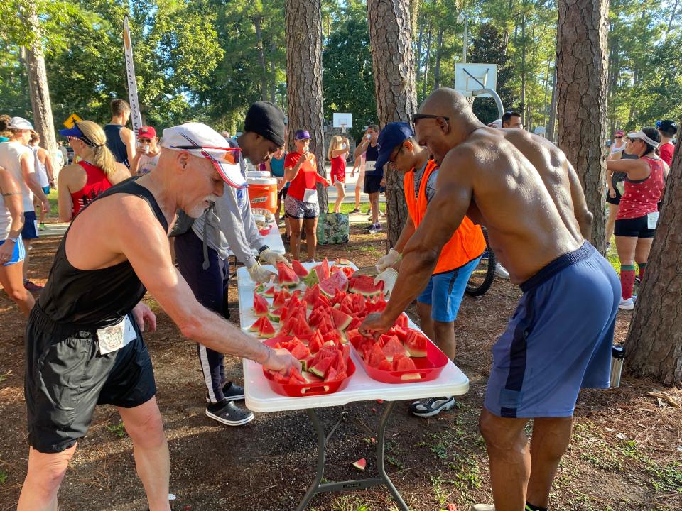 Participants of the 44th annual Jack Gamble Melon Run celebrate their 3-mile run with watermelon at Gainesville's Westside Park on Monday.