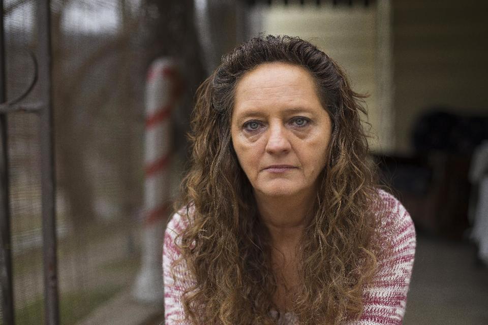 In this Monday, Dec. 19, 2016, photo, Donna Dye, who is unemployed and whose husband is disabled, sits outside her home in Minnie, Ky. She and her husband have been fighting the federal government to keep his Social Security disability checks after a local lawyer who helped them became the subject of a federal fraud investigation. (AP Photo/David Stephenson)