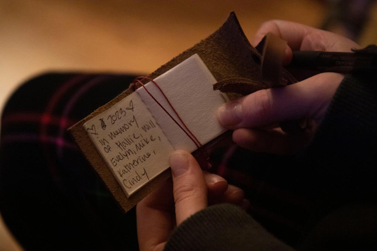 Melissa Alexander’s daughter writes the names of the six victims in the Covenant School shooting in a tiny book in Nashville, Tenn., Sunday, Nov. 26, 2023. Every year, the family records the names of people they lost in the book. It's placed on the family Christmas tree.