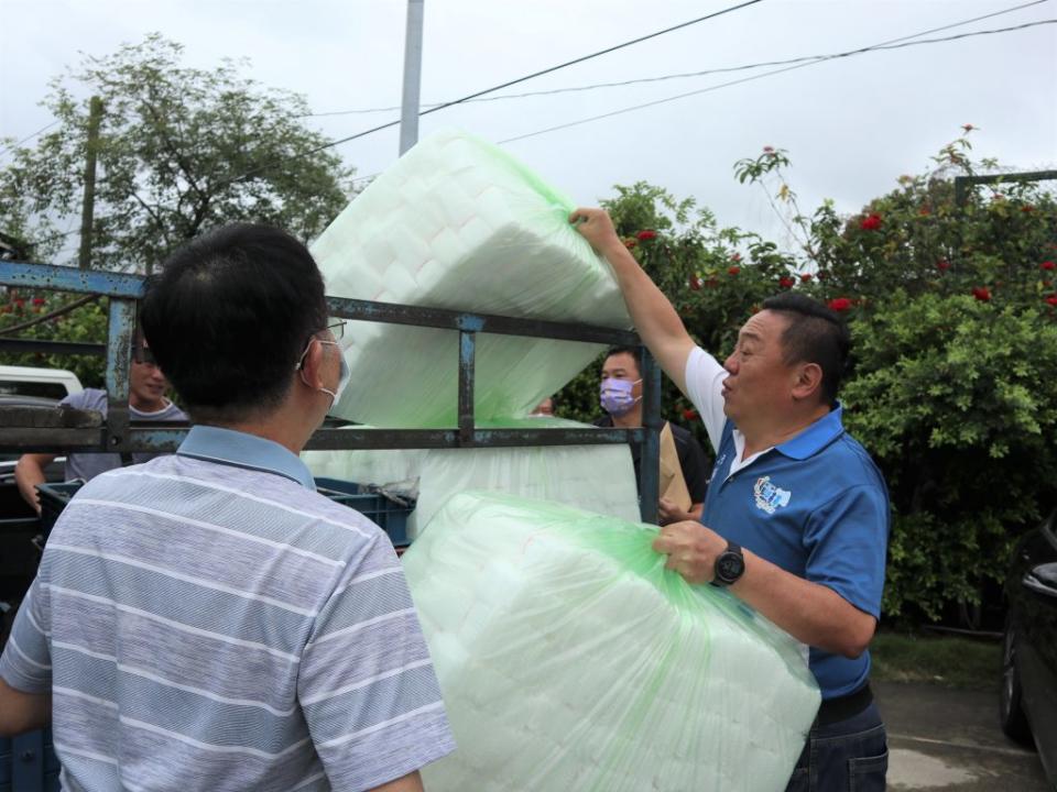 員林市長游振雄（右）幫果農將套袋搬上車。（記者吳東興攝）