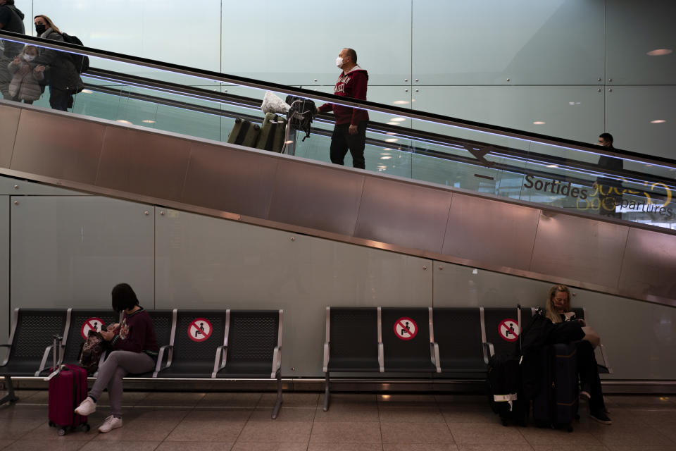 Passengers carry luggage at the airport in Barcelona, Spain, Monday, Nov. 29, 2021. Countries around the world slammed their doors shut again to try to keep the new omicron variant at bay Monday, even as more cases of the mutant coronavirus emerged and scientists raced to figure out just how dangerous it might be. (AP Photo/Joan Mateu Parra)