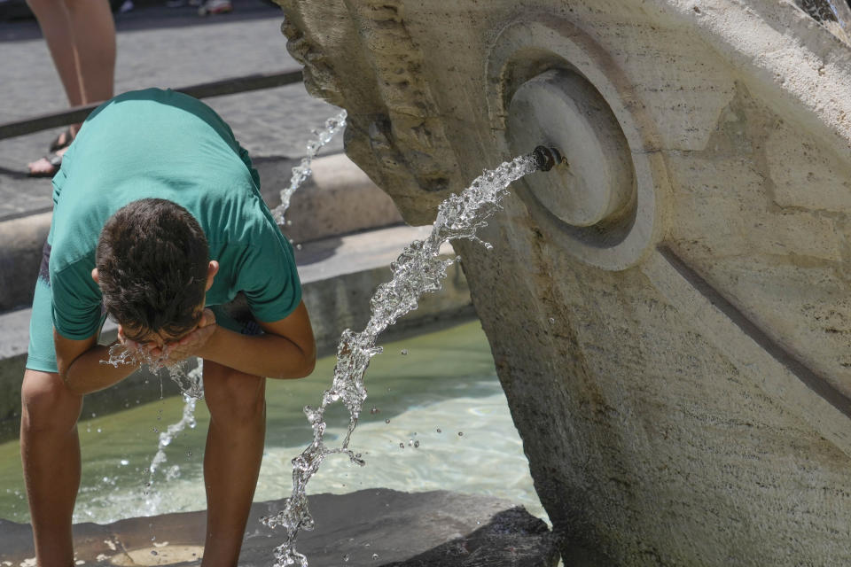 A child refreshes at the Barcaccia fountain in Rome, Tuesday, July 18, 2023. Tourist flock to the eternal city while scorching temperatures grip central Italy with Rome at the top of the red alert list as one of the hottest cities in the country. (AP Photo/Gregorio Borgia)