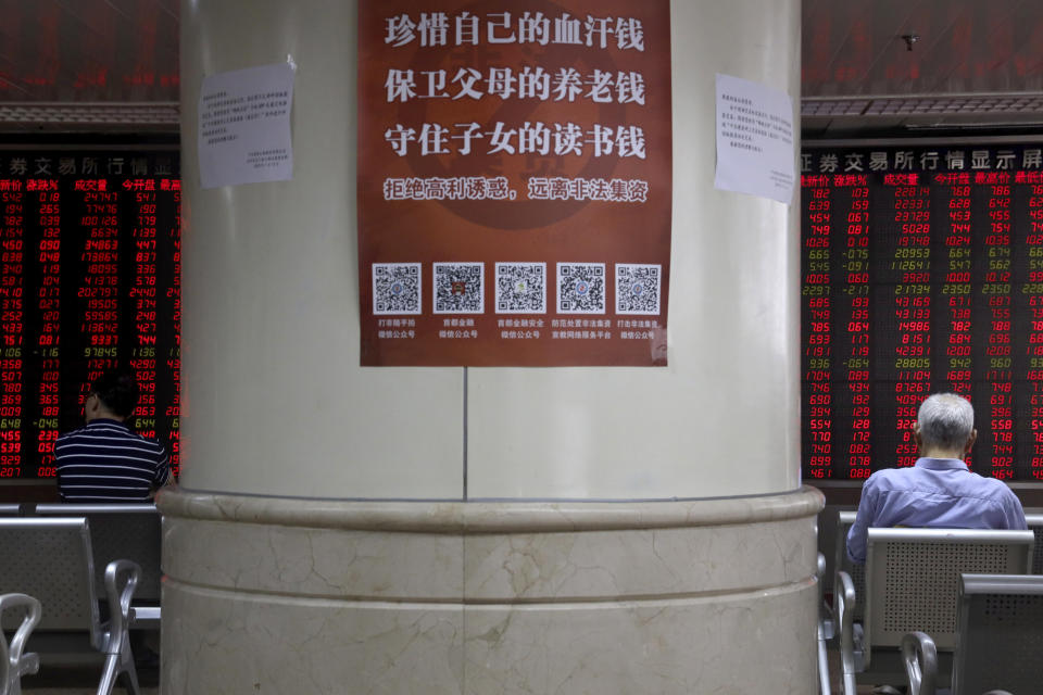 A notice with the words "Treasure your hard earned money, protection your parent's retirement funds, secure your children's education money" is displayed at a brokerage in Beijing on Friday, July 19, 2019. Asian shares rebounded Friday on hopes for progress in trade talks between China and the U.S., extending overnight gains on Wall Street.(AP Photo/Ng Han Guan)