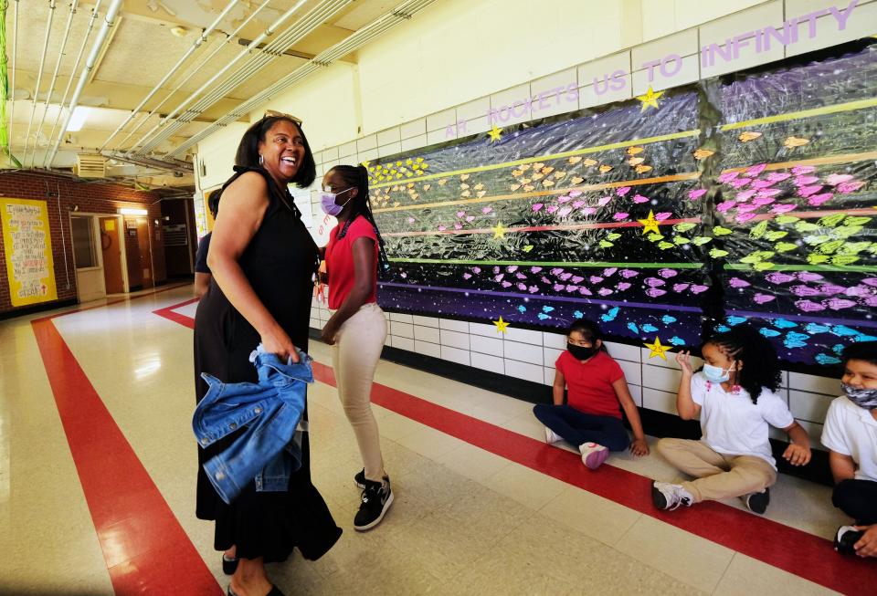 Lori Torrey, Principal at Spann Elementary School in Jackson, Miss., congratulates one of her students for achieving high academic scores on her report card.