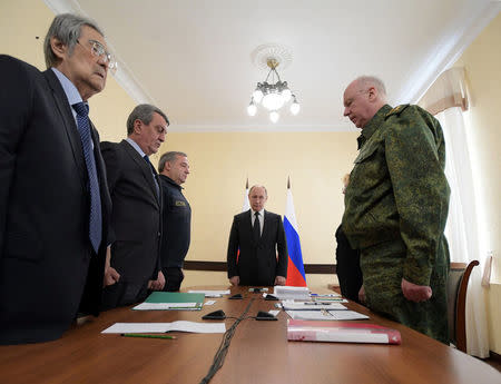 Russian President Vladimir Putin observes a minute of silence before chairing a meeting dedicated to fire, that killed at least 64 people at a busy shopping mall, in Kemerovo, Russia March 27, 2018. Sputnik/Alexei Druzhinin/Kremlin via REUTERS