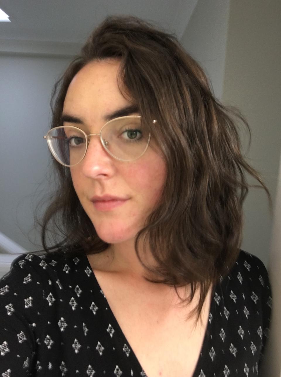 Writer with curly cropped hair in selfie photo