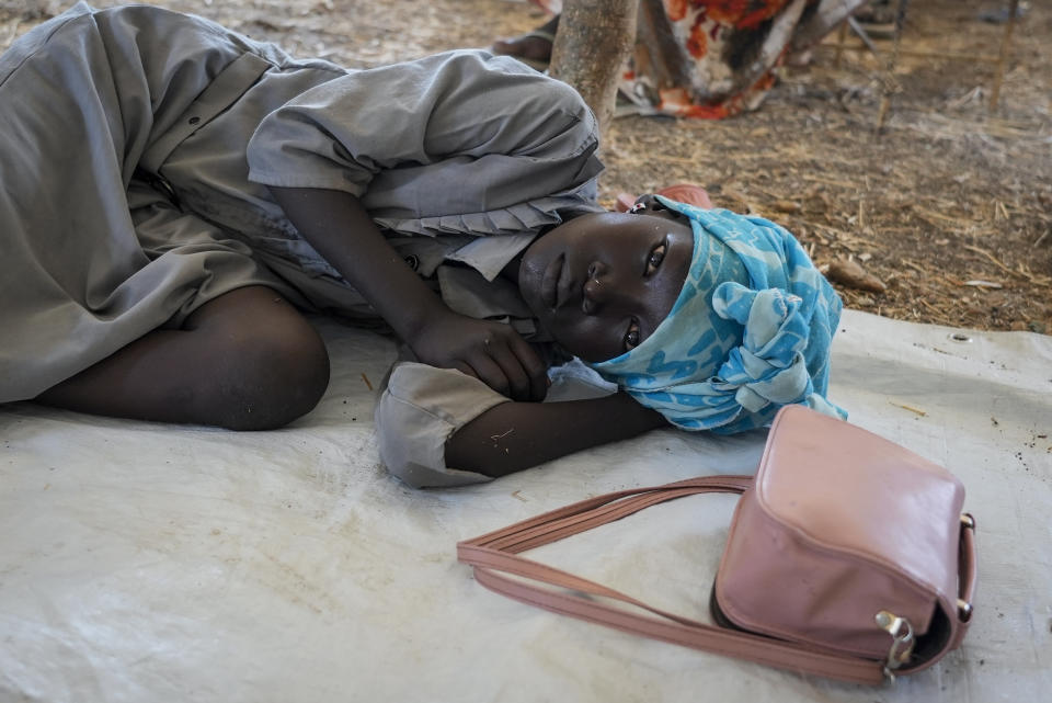 A girl who crossed from Sudan to South Sudan lies on the floor at a makeshift clinic, at the Joda border crossing in South Sudan Tuesday, May 16, 2023. Tens of thousands of South Sudanese are flocking home from neighboring Sudan, which erupted in violence last month. (AP Photo/Sam Mednick)