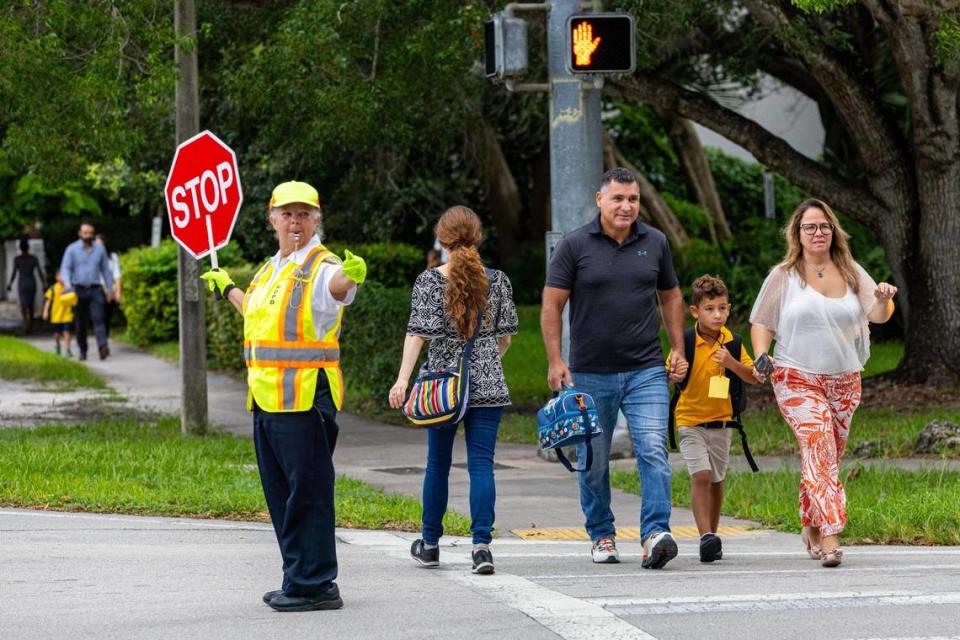 MDPD crossing guard Josefina Vina guides parents and children on the first day of school at Sunset Elementary in Miami, Florida, on Thursday, Aug. 17, 2023.