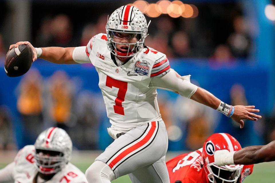 Ohio State Buckeyes quarterback C.J. Stroud (7) evades pressure from the Georgia Bulldogs during the second quarter of the 2022 Peach Bowl at Mercedes-Benz Stadium.