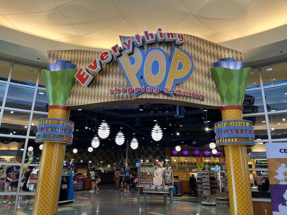 sign for the shopping and dining area at pop century resort in disney world