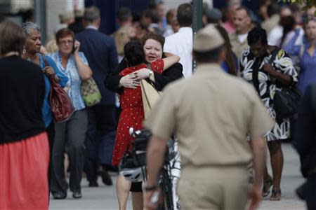Navy Yard workers, evacuated after the shooting, are reunited with loved ones at a makeshift Red Cross shelter at the Nationals Park baseball stadium near the affected naval installation in Washington, September 16, 2013. REUTERS/Jonathan Ernst