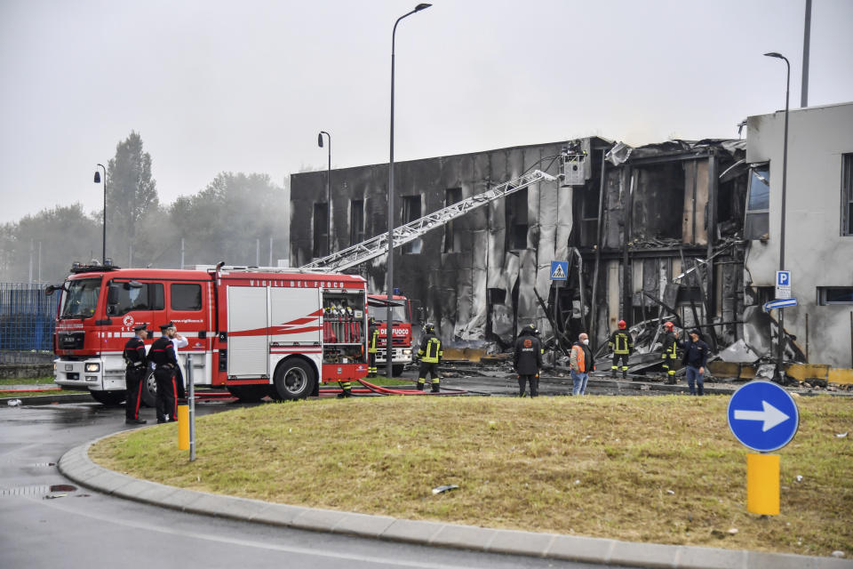 Firefighters work on the site of a plane crash, in San Donato Milanese suburb of Milan, Italy, Sunday, Oct. 3, 2021. According to media reports, a small plane carrying five passengers and the pilot crashed into an apparently vacant office building in a Milan suburb. Their fates were not immediately known. (Claudio Furlan/LaPresse via AP)