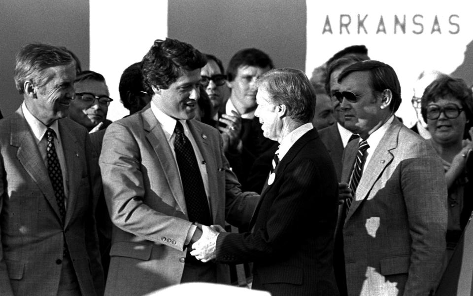 Bill Clinton, then governor of Arkansas, shakes hands with President Jimmy Carter in 1980 - AP