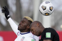 United States' Gyasi Zardes, left, and Canada's Kamal Miller, right, vie for the ball during the first half of World Cup qualifying soccer action in Hamilton, Ont.ario, Sunday, Jan. 30, 2022. (Frank Gunn/The Canadian Press via AP)