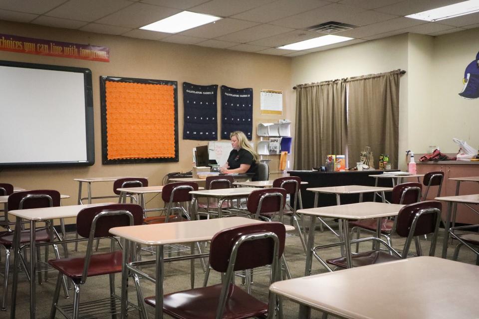 A math teacher at Trevor Browne High School in Phoenix teaching online in an empty classroom.