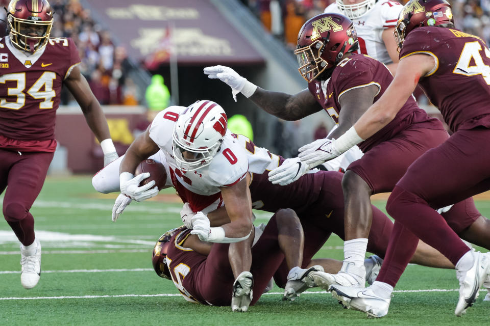 MINNEAPOLIS, MN – NOVEMBER 27: Braelon Allen #0 of the Wisconsin Badgers is tackled by Coney Durr #16 and Mariano Sori-Marin #55 of the Minnesota Golden Gophers in the second quarter of the game at Huntington Bank Stadium on November 27, 2021 in Minneapolis, Minnesota. (Photo by David Berding/Getty Images)