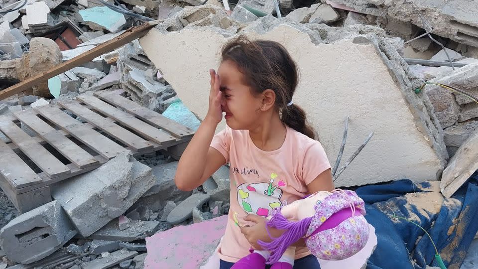 Saba, Al-Kahlot’s daughter, on the ruins of their house in Beit Lahia, in northern Gaza, on October 10, 2023. - Saeed Al-Kahlot