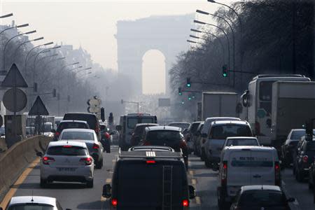 Rush hour traffic fills an avenue leading up to the Arc de Triomphe which is seen through a small-particle haze at Neuilly-sur-Seine, Western Paris, March 13, 2014 as warm and sunny weather continues in France. REUTERS/Charles Platiau