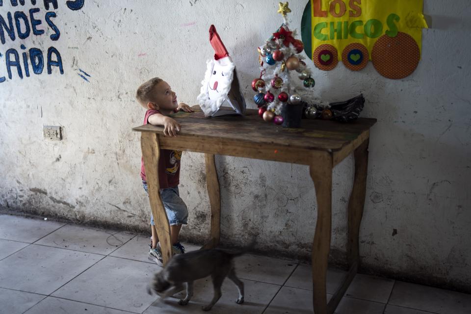 A child looks at a Santa craft at a pre-Christmas celebration organized by "Los Chicos de la Via" soup kitchen, in Buenos Aires, Argentina, Saturday, Dec. 23, 2023. (AP Photo/Rodrigo Abd)