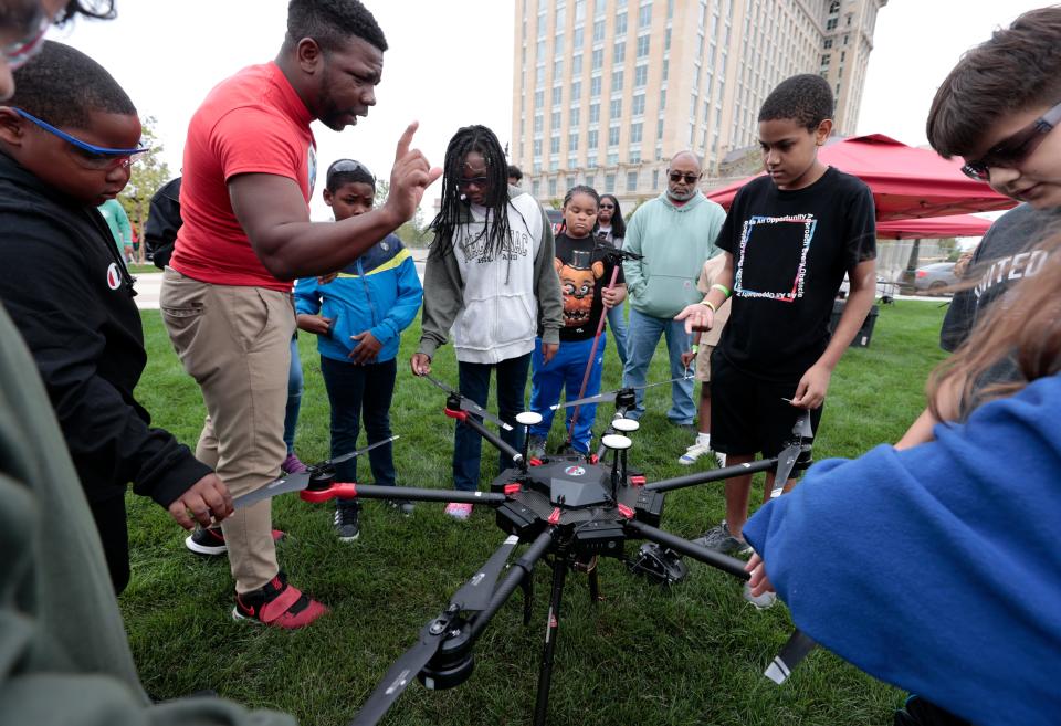 Tony Reid, 36 of New York City and with Drone Cadet, talks to kids about a large drone during an exercise at youth drone demo day put on by Code 313 in front of Ford’s Michigan Central Station in Detroit on Saturday, September 9, 2023. From an obstacle course to drone mapping 150 kids ages seven to seventeen from various Metro Detroit schools learned drone safety and got to fly drones around the park area with adult supervision.