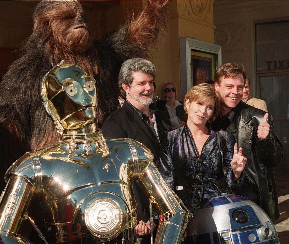 Characters from the film "Star Wars" join writer and director George Lucas, left, Carrie Fisher, center, and Mark Hamill at the world premiere of "Star Wars Special Edition" Saturday, Jan. 18, 1997, in the Westwood section of Los Angeles.  The movie  was first released 20 years ago. (AP Photo/Rene Macura)