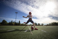 Simon Fraser University football team kicker Kristie Elliott, kicks a ball while posing for a photograph before practice in Burnaby, B.C., Tuesday, Sept. 21, 2021. The 21-year-old Elliott booted a pair of successful conversions against Oregon’s Linfield University on Sept. 11, becoming the first Canadian woman to play in — and score in — an NCAA football game. (Darryl Dyck/The Canadian Press via AP)