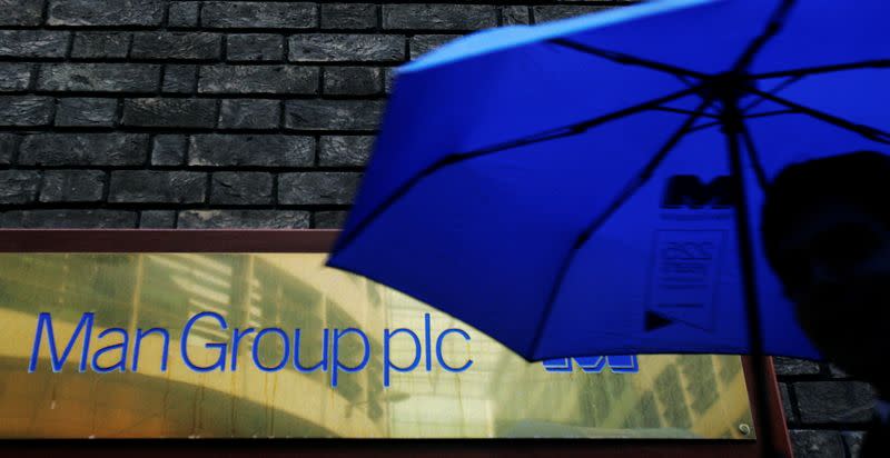 FILE PHOTO: A man passes a sign for fund manager Man Group in London