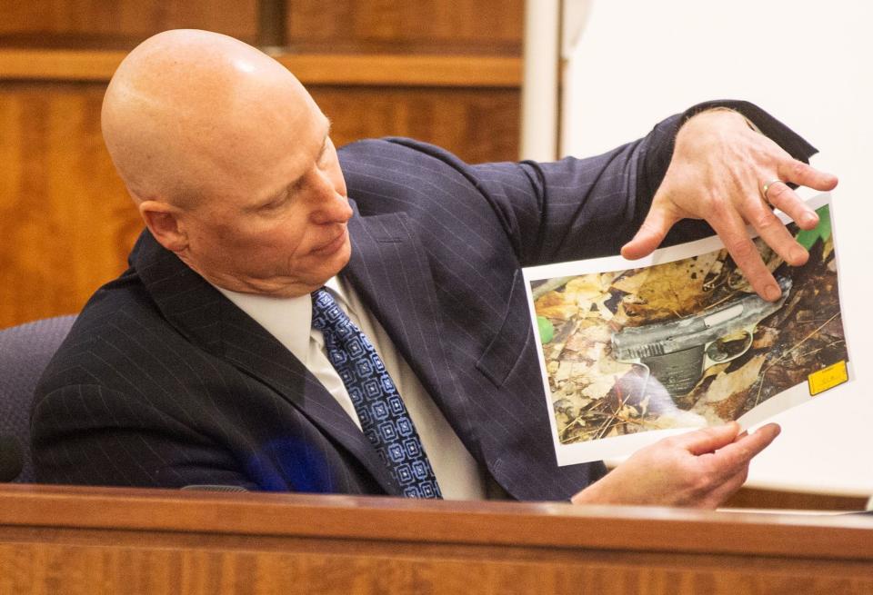 Massachusetts State Trooper Stephen Gallagher holds a picture of a small handgun found in a wooded area near the crime scene during the murder trial of the former New England Patriots player Aaron Hernandez at the Bristol County Superior Court in Fall River, Massachusetts February 13, 2015. REUTERS/Aram Boghosian/Pool (UNITED STATES - Tags: CRIME LAW SPORT FOOTBALL)
