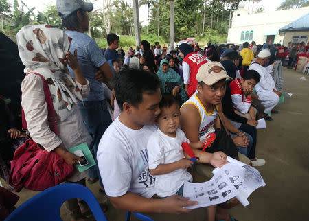 Residents staying at evacuation centers, due to the assault of government troops against pro-Islamic State militant groups, wait for their names to be called before being allowed to return home, at an open gym in Basak, Malutlut district in Marawi city, southern Philippines October 29, 2017. REUTERS/Romeo Ranoco