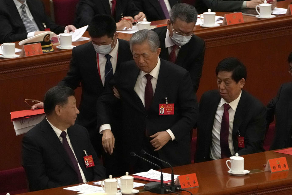 Former Chinese President Hu Jintao, center, is helped during the closing ceremony of the 20th National Congress of China's ruling Communist Party at the Great Hall of the People in Beijing, Saturday, Oct. 22, 2022. (AP Photo/Andy Wong)