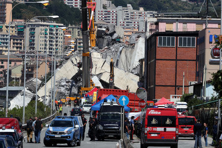 FILE PHOTO: Firefighters and rescue workers stand at the site of a collapsed Morandi Bridge in the port city of Genoa, Italy August 15, 2018. REUTERS/Stefano Rellandini