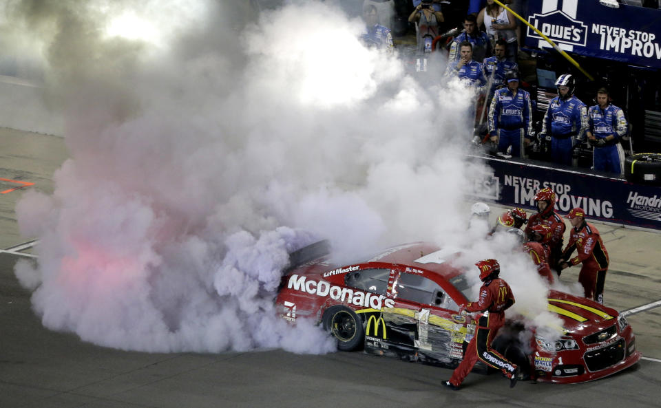 Jamie McMurray is helped from his car during a NASCAR Sprint Cup Series auto race at Kansas Speedway in Kansas City, Kan., Saturday, May 10, 2014. (AP Photo/Charlie Riedel)