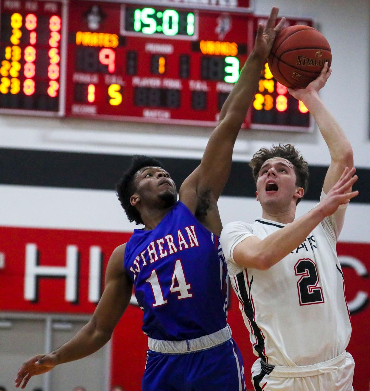 Wisconsin Lutheran senior Jordan Glenn (14) gets called for a foul as Pewaukee senior guard Ashton Janowski (2) drives to the basket during their basketball game Tuesday night. Glenn collapsed before Lutheran's game Friday at West Allis Central but regained consciousness and left the court under his own power.