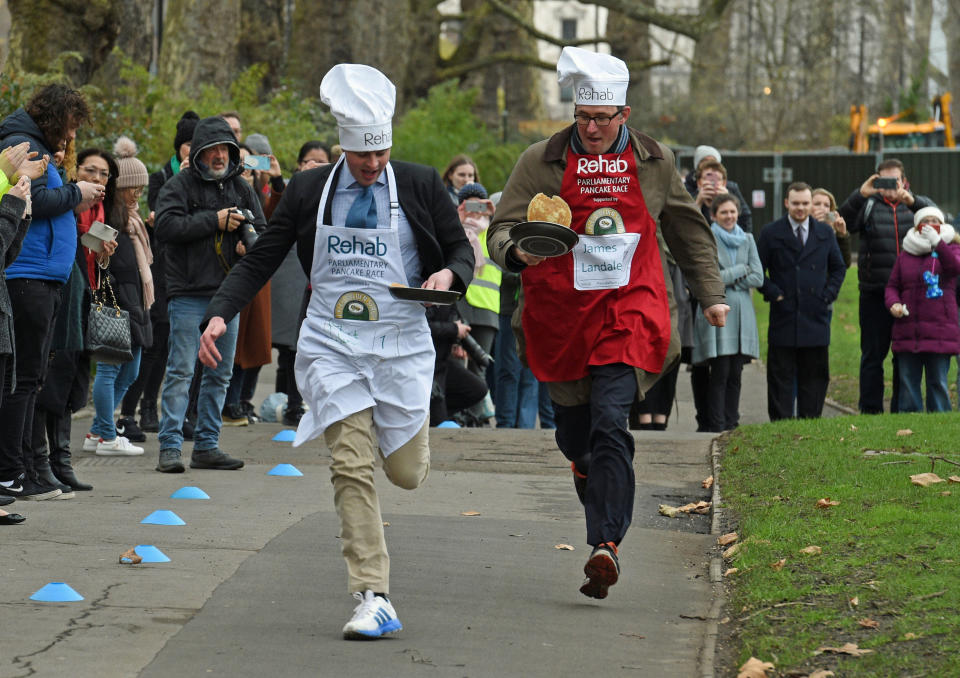 <p>Matt Warman MP (left) and BBC News correspondent James Landale taking part in the Parliamentary Pancake Race in aid of the Rehab disability charity, at Victoria Tower Gardens in Westminster, London. (Kirsty O’Connor/PA Wire) </p>