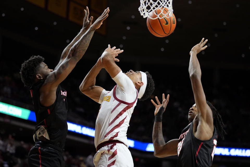 Iowa State guard Tamin Lipsey, center, drives to the basket between Houston guard Jamal Shead, left, and forward Joseph Tugler, right, during the second half of an NCAA college basketball game, Tuesday, Jan. 9, 2024, in Ames, Iowa. (AP Photo/Charlie Neibergall)