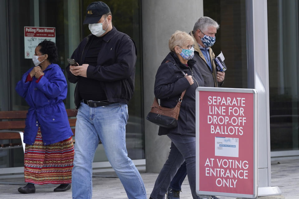 People wear mask as they leave at Indian Trails Public Library after voting in Wheeling, Ill., Wednesday, Oct. 21, 2020. (AP Photo/Nam Y. Huh)