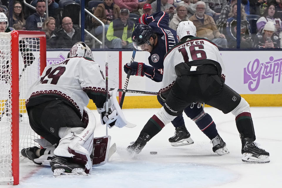 Arizona Coyotes left wing Jason Zucker (16) keeps Columbus Blue Jackets center Cole Sillinger (4) away from the puck in front of Coyotes goaltender Connor Ingram, left, during the second period of an NHL hockey game Thursday, Nov. 16, 2023, in Columbus, Ohio. (AP Photo/Sue Ogrocki)